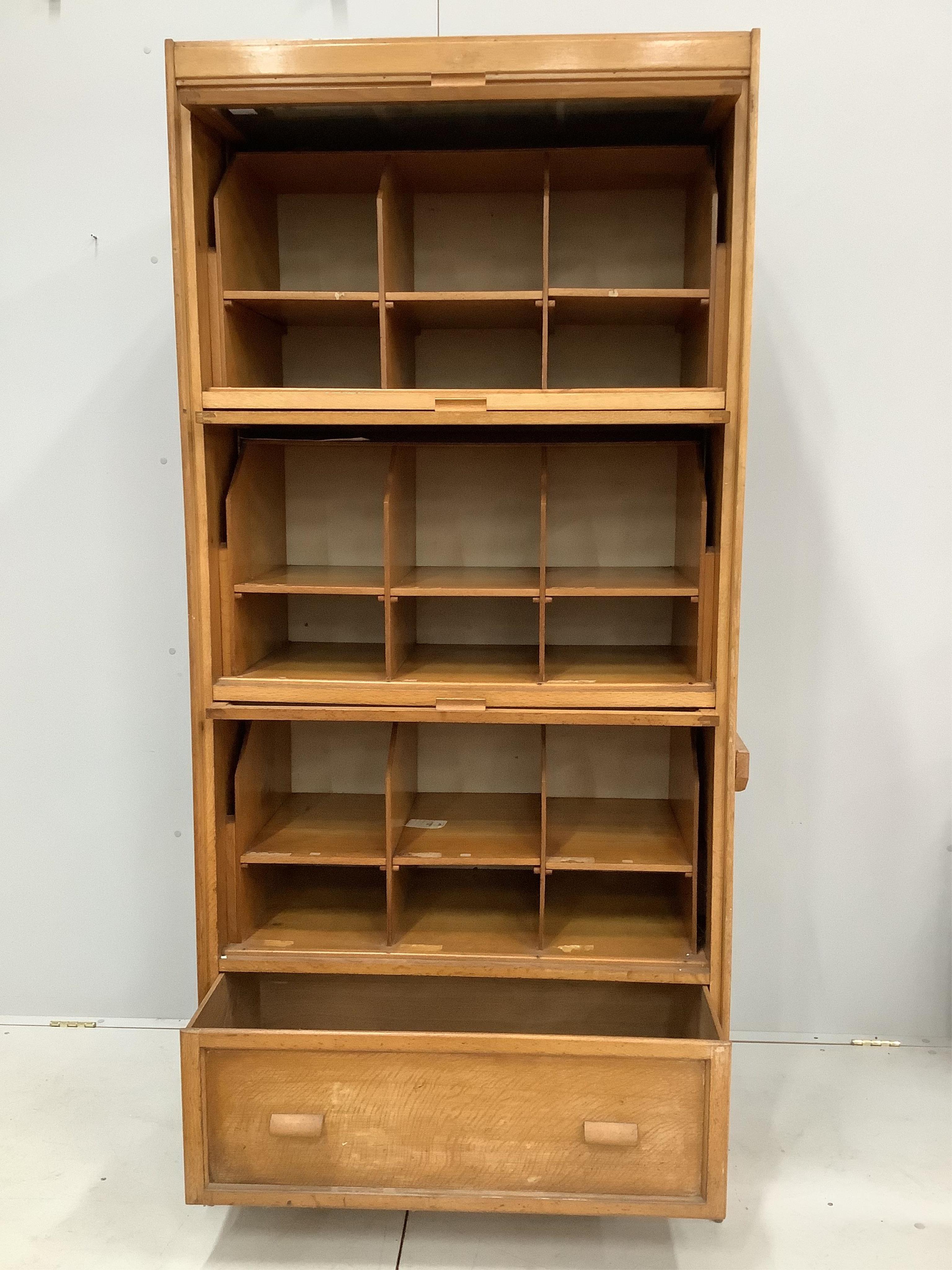 A mid century glazed oak haberdasher's cabinet, width 92cm, depth 50cm, height 198cm. Condition - fair